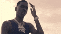 a man wearing a blue tank top and a necklace with the word brg on it