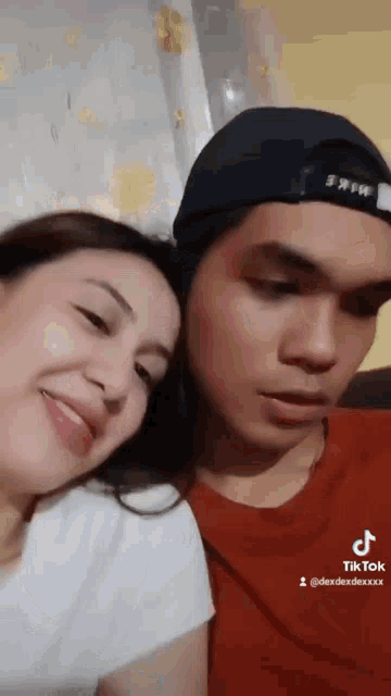 a man and a woman are sitting next to each other and smiling .