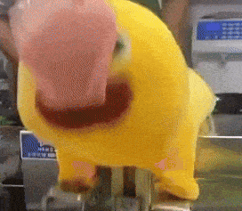 a yellow stuffed animal with a pink nose is being processed