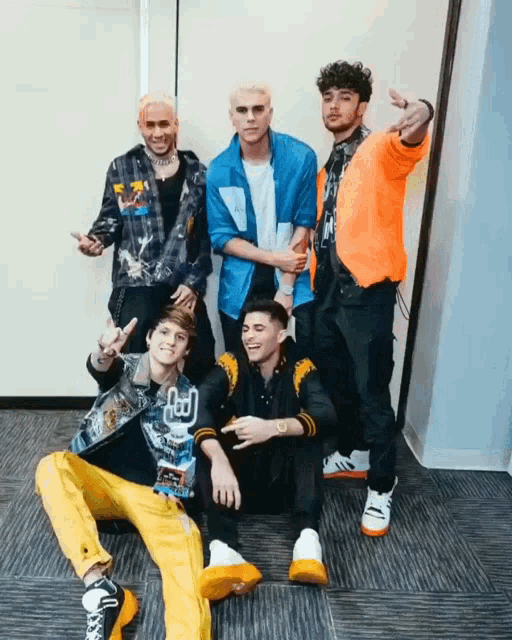 a group of young men are posing for a picture and one of them is wearing a shirt that says ' a '