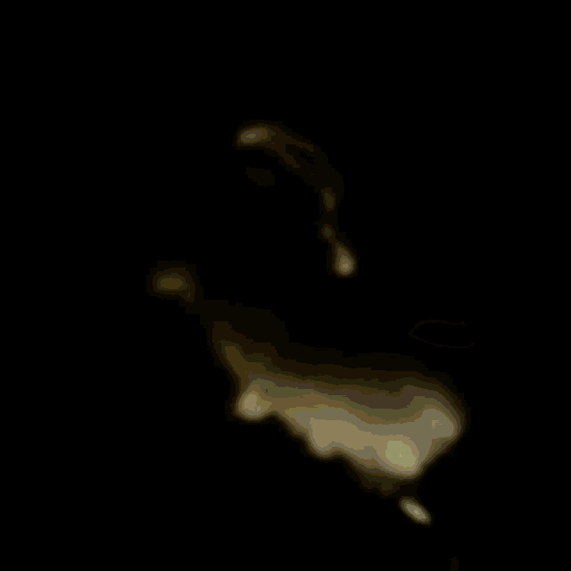 a man with a mustache is sitting in a dark room looking at something .