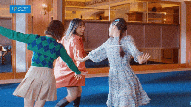 three girls are dancing in a room with a sign that says up front works