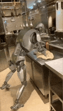 a robot is cleaning a pizza dough on a counter