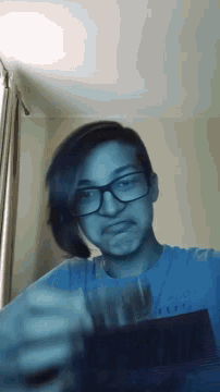 a girl wearing glasses and a blue shirt that says delft on the back