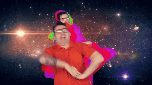 a man in a red shirt is carrying another man in a rainbow colored shirt