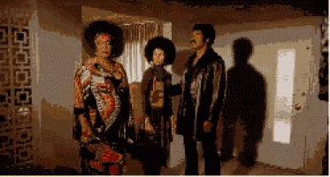 a group of people standing in a room with their shadows cast on the wall