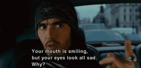 a man in a beanie is sitting in the back seat of a car and talking to someone .
