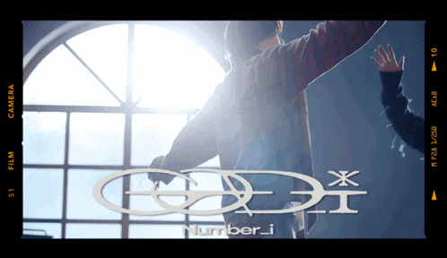 a man stands in front of a window with his arms outstretched in front of a sign that says number i