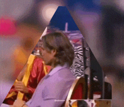 a man in a purple shirt is sitting in a chair with a zebra print chair in the background .