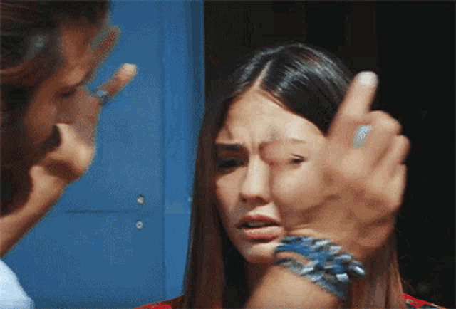 a man is pointing at a woman with a ring on her wrist