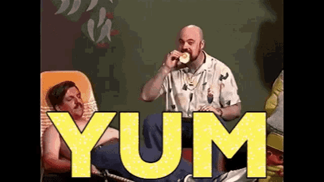 a man is sitting in a chair drinking from a cup while another man is sitting in a chair .