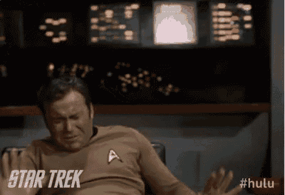 a man wearing a star trek shirt is sitting down