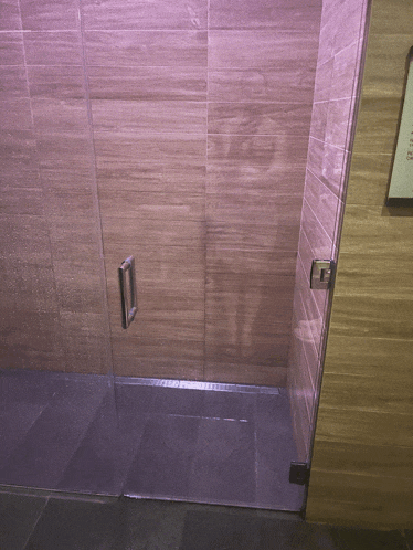 a bathroom with a glass door and a sign on the wall that says ' a '