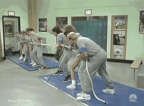 a group of people are playing tug of war in a gym sponsored by nbc .