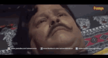 a man with a mustache is laying on a bed with a watermark that says ' jain ' on it