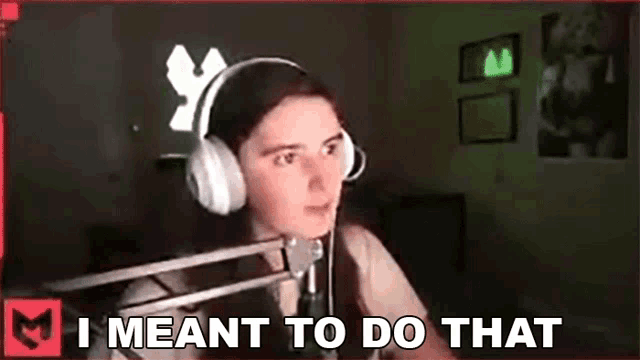 a girl wearing headphones is sitting in front of a microphone and says `` i meant to do that '' .