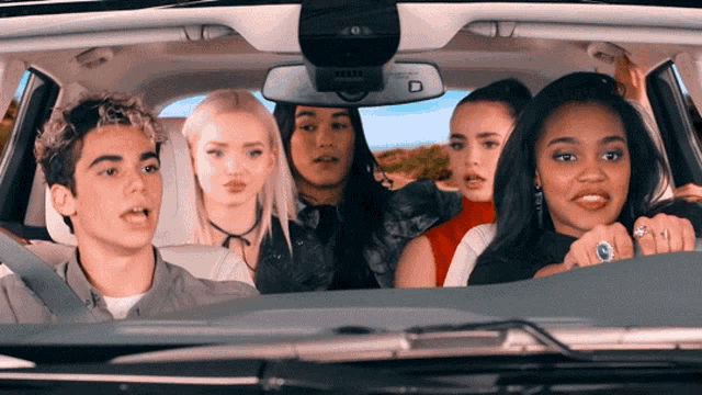 a group of people are sitting in a car with a rear view mirror that says ' airbag ' on it