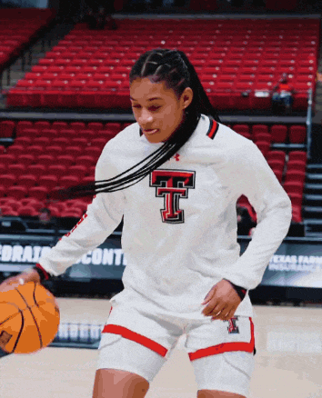 a female basketball player wearing a white shirt with the letter t on the front