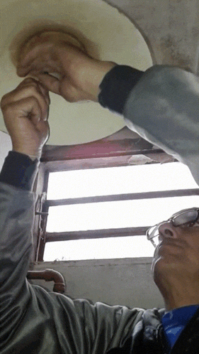 a man wearing glasses looks up at something
