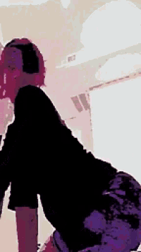 a person wearing headphones is dancing in a room .