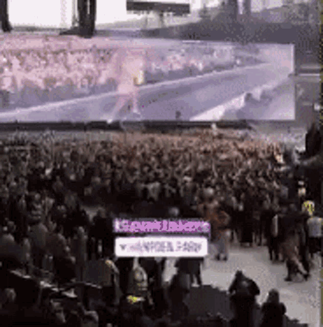 a large crowd of people are gathered in front of a large screen with a sign that says ' k9 ' on it
