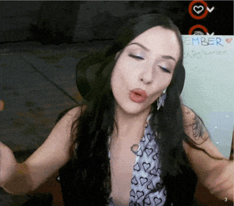 a woman blows a kiss in front of a board that says ember on it
