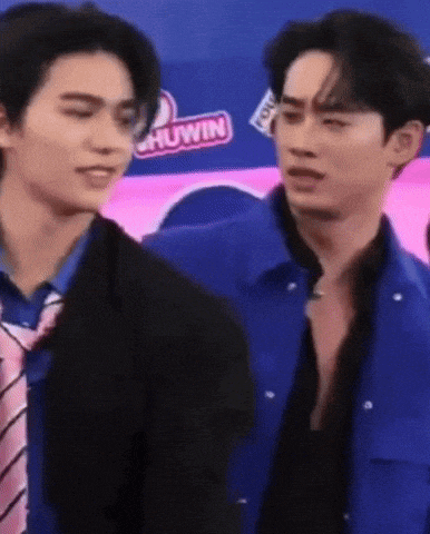 two men are standing next to each other and one is wearing a blue jacket and tie .