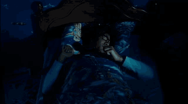 a person laying in bed with a blue blanket that says ' disney '