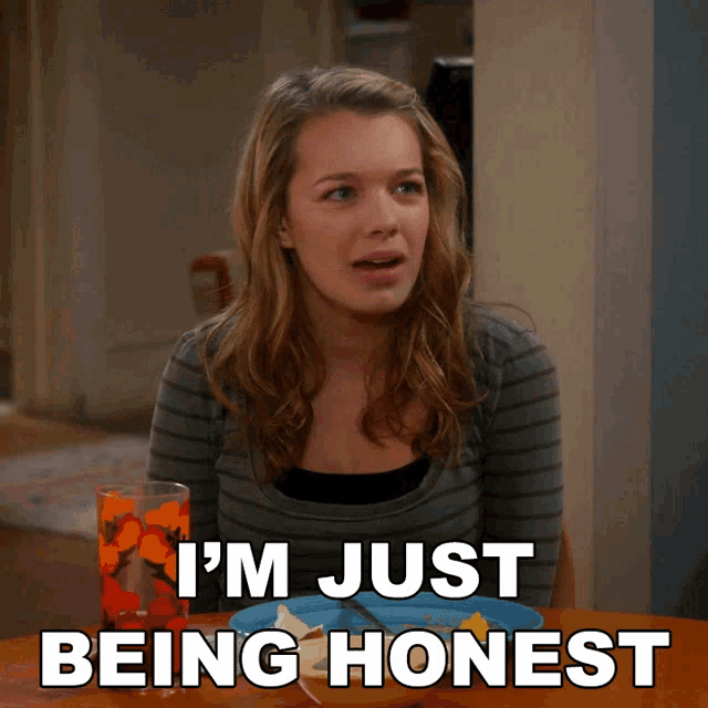 a woman sitting at a table with the words i 'm just being honest written below her