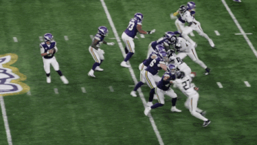 a football player with the number 27 on his jersey is being tackled