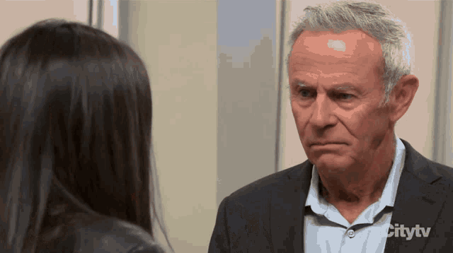 a man in a suit talks to a woman in a city tv ad