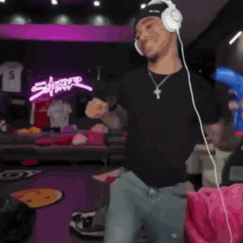 a man wearing headphones is dancing in a room with a number 15 jersey on the wall