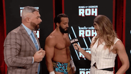 a man and a woman are standing in front of a screen that says ring of honor