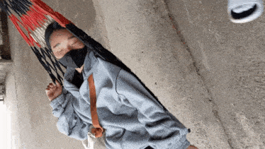 a person wearing a mask is laying in a hammock with their eyes closed