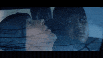 a man and a woman are looking out a car window