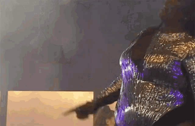 a woman in a silver and purple dress is holding a gun