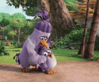 a couple of purple birds hugging each other on a path