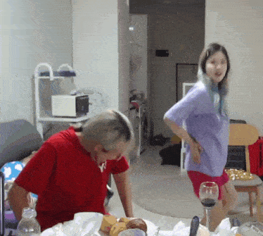 a woman in a purple shirt stands next to a man in a red shirt