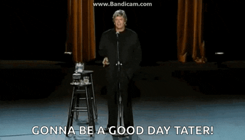 a man stands in front of a microphone on a stage and says gonna be a good day tater
