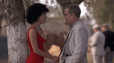 a man and a woman are standing next to each other holding hands .