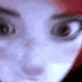 a close up of a person 's face with red hair and a white mask on .