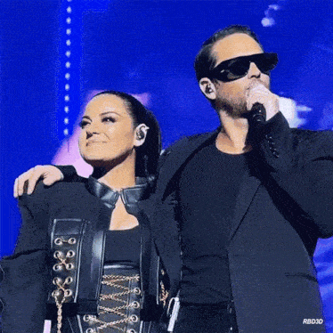 a man and a woman are standing next to each other on a stage with a blue background that says rbd30