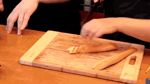 a person cutting a piece of salmon on a cutting board