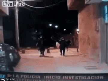 a group of police officers walking down a street at night