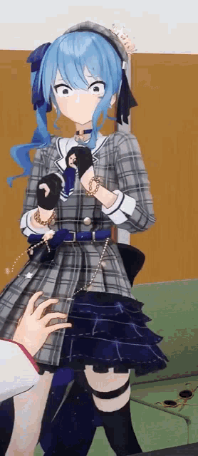 a girl with blue hair and a plaid dress is being touched by a person 's hand .