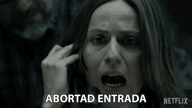 a woman is screaming in front of a microphone and the words abortad entrada are above her head