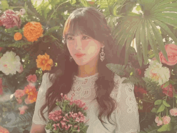 a woman in a white lace top is holding a bouquet of flowers