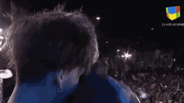 a man is kissing another man in front of a crowd with la vida en vivo written on the bottom