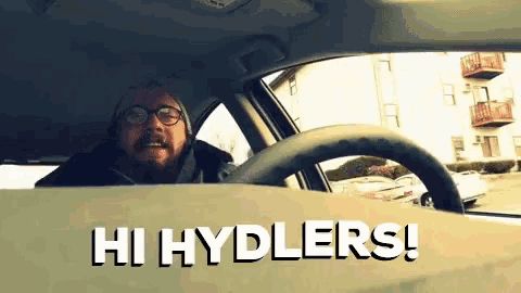 a man is driving a car with the words hi hydlers on the dashboard