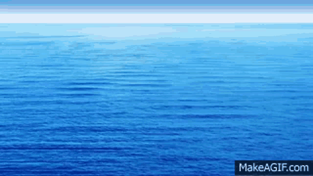 a large body of water with a blue sky in the background .